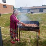 Ženska peče meso na žaru.