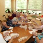 Na zadnji sliki starejše ženske dokončujejo pripravo sladice in jo postrežejo v plastičnih kozarcih. Vzdušje je veselo, ženske si medsebojno pomagajo in preizkušajo končno jed. Miza je obložena z majhnimi kozarci z okusno sladico.